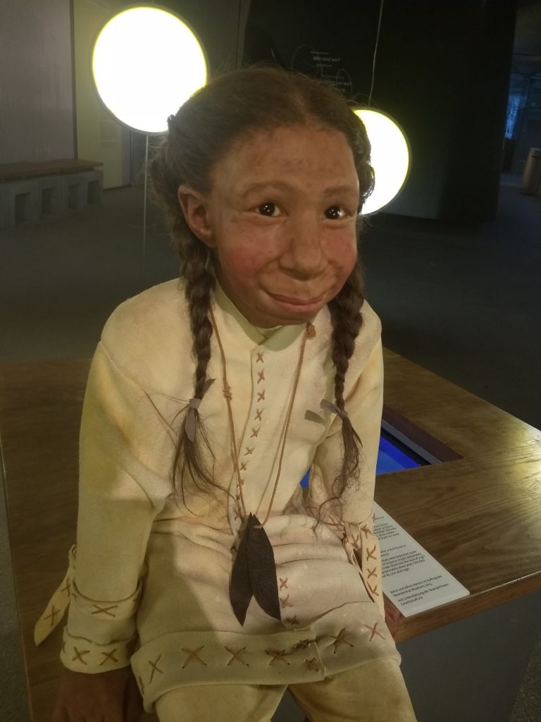 Neanderthaler Mädchen sitzt im Museum